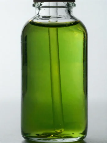 Λάδι αβοκάντο σε μικρό μπουκάλι και μπολάκι σε φωτεινό, ουδέτερο φόντο