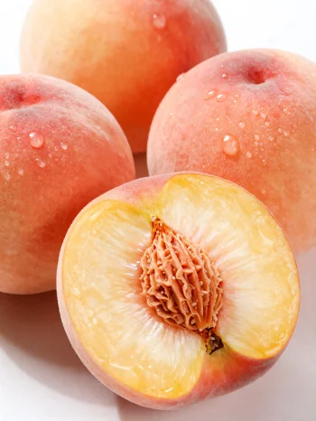 Ολόκληρα και κομμένα ροδάkina σε ξύλινο τραπέζι, δίπλα σε ποτήρι χυμό