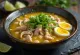 Soto ayam με φύτρες σερβιρισμένο, με φέτες λάιμ και φρέσκο κρεμμυδάκι