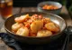 Tteokbokki με fish cake, σερβιρισμένο με σουσάμι και φρέσκο κρεμμυδάκι