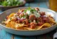 Chilaquiles με longaniza, σερβιρισμένα με φρέσκο κόλιανδρο, γιαούρτι και τυρί