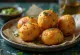 Φρεσκοφτιαγμένο Batata Vada, τραγανές πατατομπάλες, διακοσμημένες με κόλιανδρο